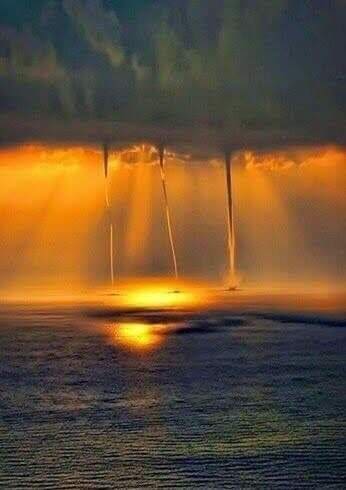 A water spout is shown with the sun shining.